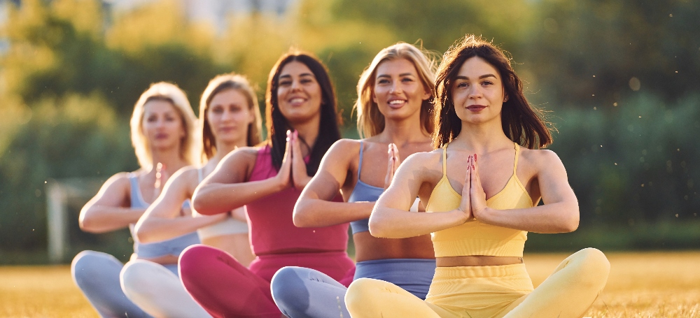 Group of women, outdoor meditation in lotus pose. 