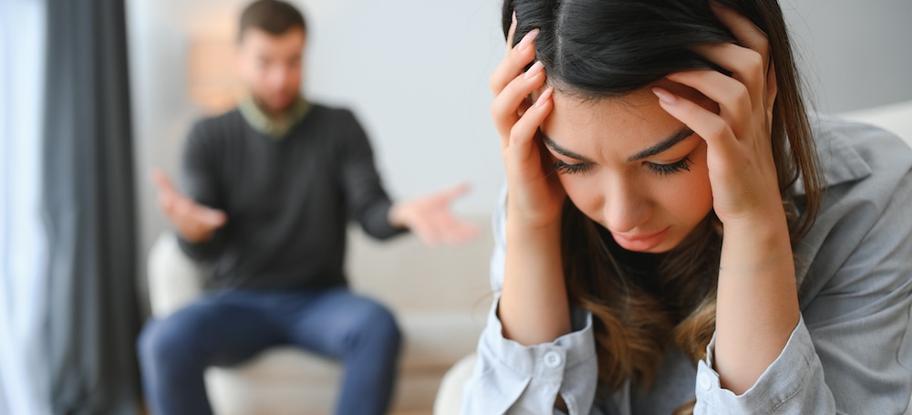 Upset man is shouting at woman who is covering her face