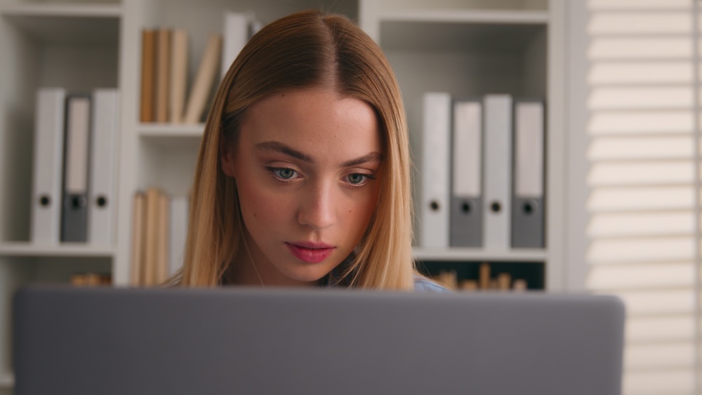 Young woman intently searching on her laptop