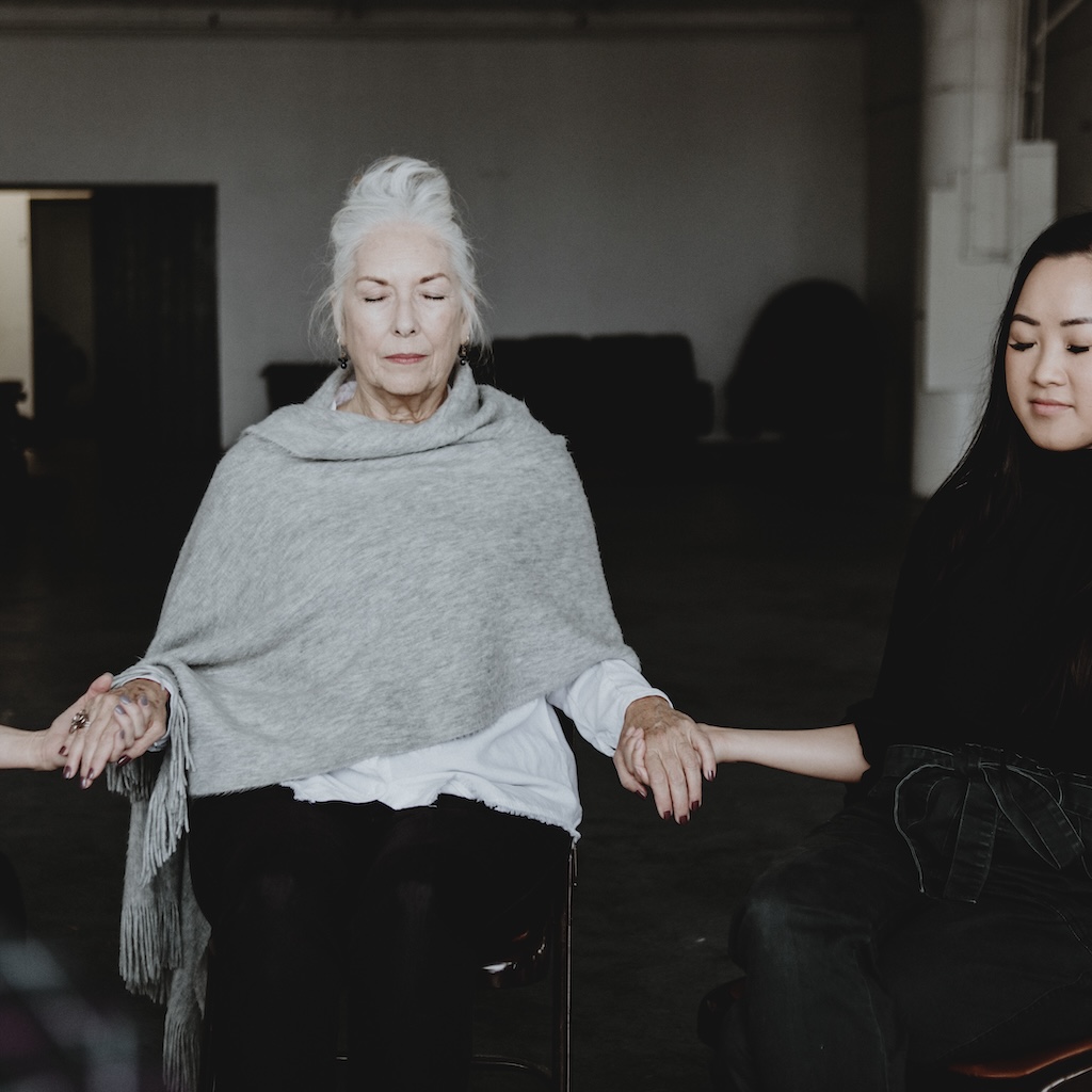 Diverse group of women holding hands in women's group therapy session