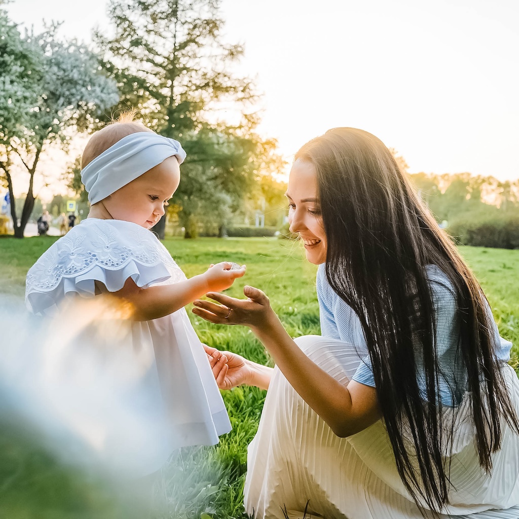 Mother and little daughter with apple tree flower.