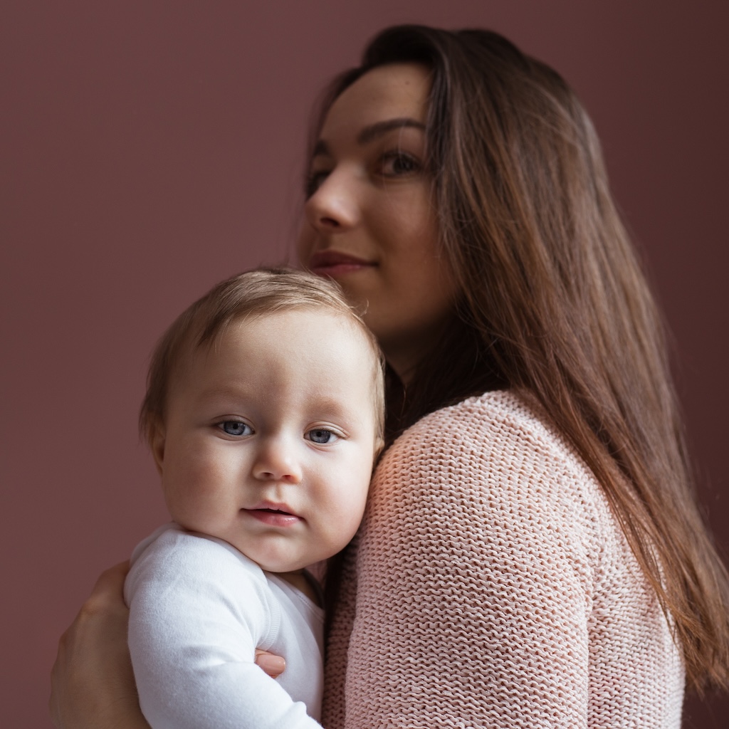 Young mother with little baby at home, struggling with postpartum depression.