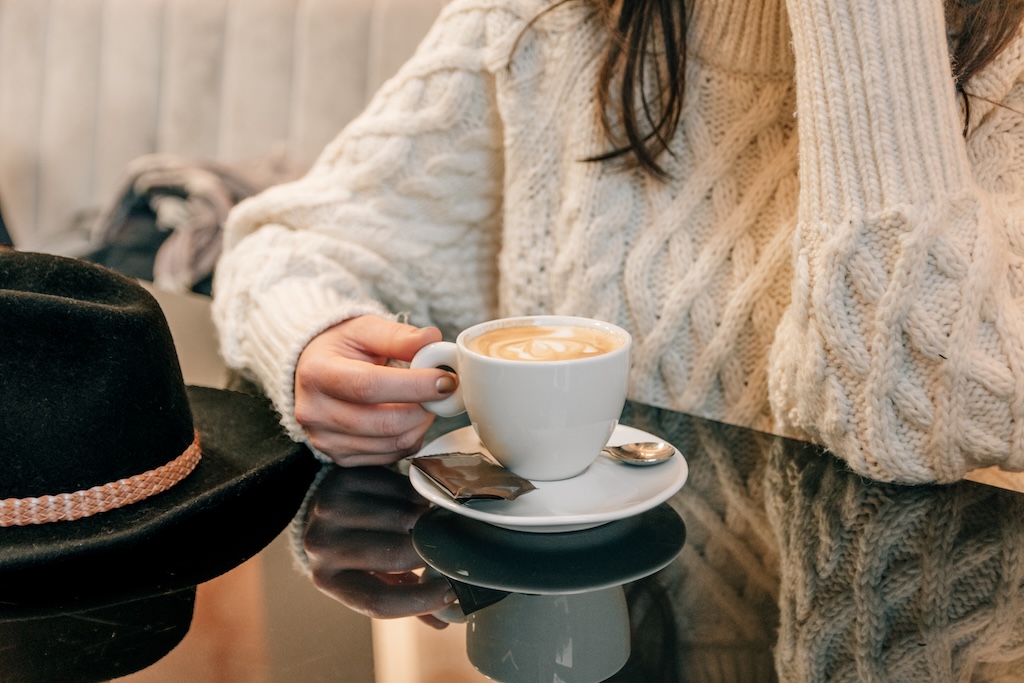 Woman sipping coffee by herself at a cafe. 