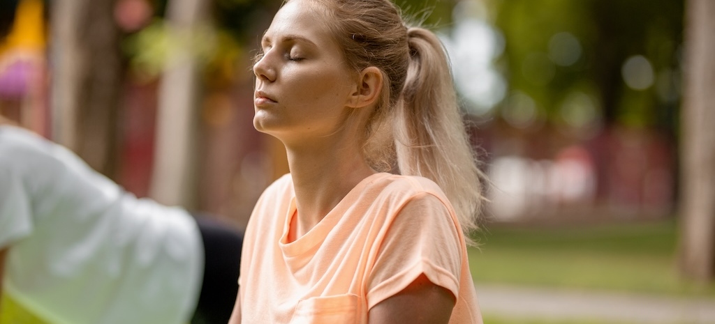 Woman doing a grounding exercise outdoor yoga.